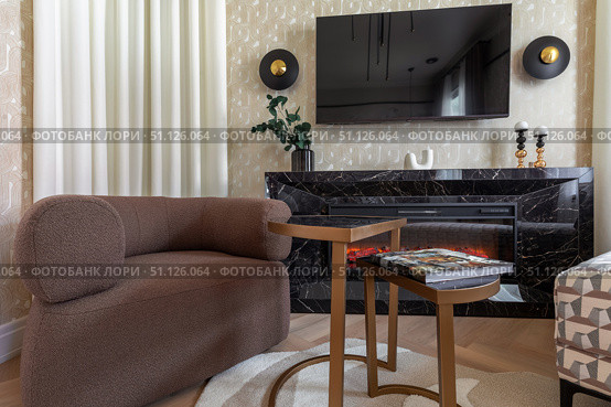 Modern Lounge Area with Armchair and Electric Fireplace. Стоковое фото, фотограф Дмитрий Головач / Фотобанк Лори