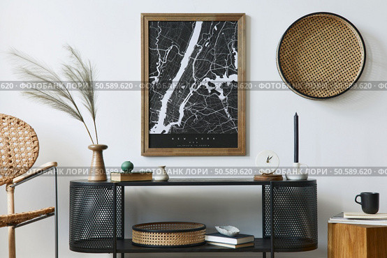 Modern scandinavian living room interior with mock up poster frame, design commode, leaf in vase, rattanarmchair, book and elegant accessories in stylish home decor. Template. . Стоковое фото, агентство Ingram Publishing / Фотобанк Лори