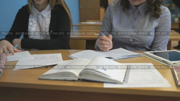Молодая ученица пишет в записной книжке в классе. Стоковое видео, видеограф worker / Фотобанк Лори