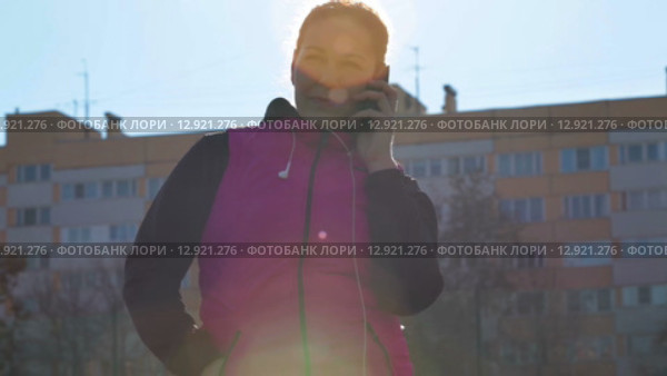 Молодая женщина разговаривает по сотовому телефону на стадионе. Стоковое видео, видеограф Кекяляйнен Андрей / Фотобанк Лори