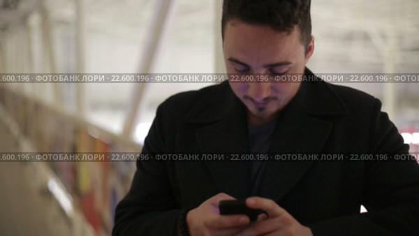 Молодой брюнет набирает смс-сообщение. Стоковое видео, видеограф Загородний Кирилл / Фотобанк Лори