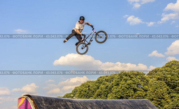 Молодой человек участвует в соревнованиях по BMX на велосипеде в Парке Горького в Москве/ Young man doing tricks in the air on a BMX bike. BMX rider (2018 год). Редакционное фото, фотограф Iva Noel / Фотобанк Лори