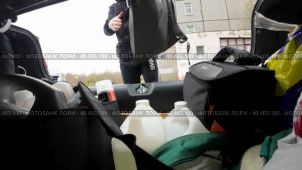 Молодой мужчина укладывает рюкзаки в багажник автомобиля и закрывает крышку багажника. Вид изнутри багажника машины. Стоковое видео, видеограф Sergei Gorin / Фотобанк Лори