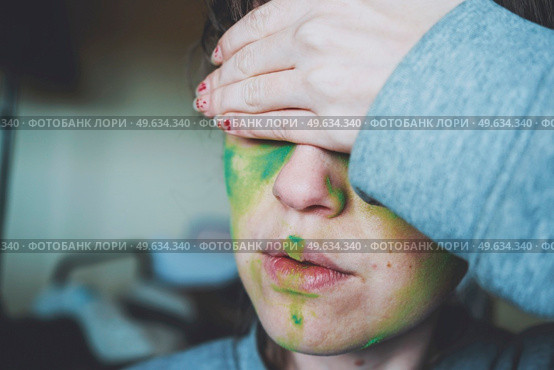 Moody portrait of a young woman with her face painted of green. Стоковое фото, агентство Ingram Publishing / Фотобанк Лори