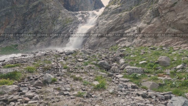 Мощный поток воды падает со скалы в горах. Красивый водопад. Камера движется параллельно водопаду. Красивые дикие места. Стоковое видео, видеограф Воловодов Владимир / Фотобанк Лори