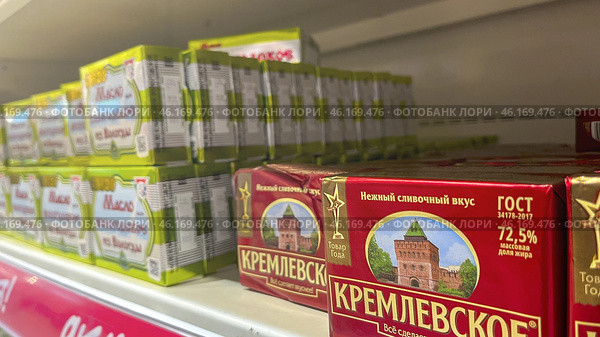 Moscow December 04, 2024, Butter in packaging on a store counter. Concept of increasing prices for butter. Refrigerator in a grocery store with briquettes of natural butter. Редакционное фото, фотограф Скрипачев Антон / Фотобанк Лори