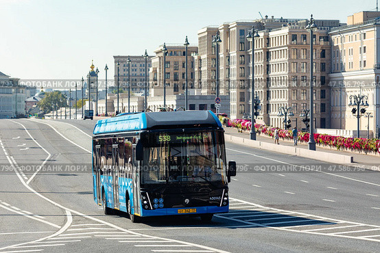 Moscow, Russia - 08.26.2024: Blue electrobus drives down the street in Moscow, front side view. Electric bus in motion. Moscow transport. Редакционное фото, фотограф Ирина Михайличенко / Фотобанк Лори