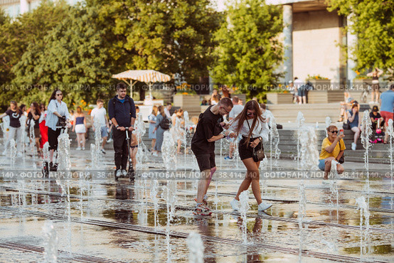 MOSCOW, RUSSIA - JUNE 28, 2022: Abnormally hot summer weather in the city. Children and adults bathe in the jets of a dry fountain in the Muzeon Park in Moscow. Редакционное фото, фотограф Photojuli / Фотобанк Лори