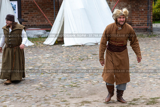 Moscow Russia - september 19 2021: Historical festival Courtyard of the 17th century. Historical reconstruction in the Krutitsky farmstead. A beggar man in historical rags walks through the yard. Редакционное фото, фотограф Yuriy Savin / Фотобанк Лори