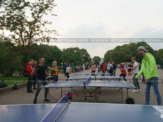 Moscow, Russia - September 5, 2019: Photography of people  playing table tennis. Photography of street ping-pong sports competitions in the Gorky park in autumnday. Редакционное фото, фотограф YuryKara / Фотобанк Лори