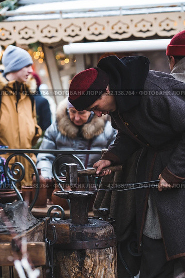 Moscow seasons. A traditional craft. Blacksmith's work with metal. Russian traditions. Hammer and anvil. Moscow. Russia (2023 год). Редакционное фото, фотограф Photojuli / Фотобанк Лори