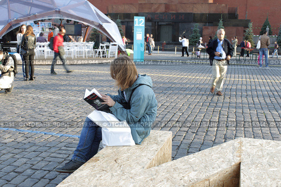 Московский фестиваль "Книги России" 2015 на Красной площади, молодой человек зачитался книгой. Редакционное фото, фотограф Дмитрий Неумоин / Фотобанк Лори