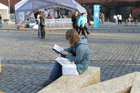 Московский фестиваль "Книги России" 2015 на Красной площади, молодой человек зачитался книгой. Редакционное фото, фотограф Дмитрий Неумоин / Фотобанк Лори