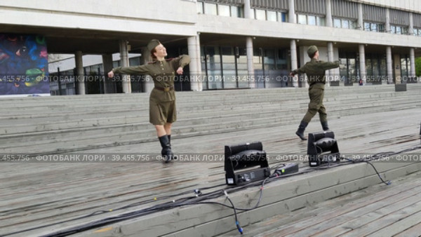 МОСКВА, РОССИЯ - 9 мая 2022 года: Артисты в советской военной форме исполняют танец в честь 77-й годовщины Победы над фашизмом. Праздник День Победы. Праздничные мероприятия в Московском парке Музеон. MOSCOW, RUSSIA - MAY 9, 2022: Artists in Soviet military uniforms perform a dance in honor of the 77th anniversary of the Victory over Fascism. Victory Day holiday. Festive events in the Moscow Muzeon Park. Редакционное видео, видеограф Ирина / Фотобанк Лори