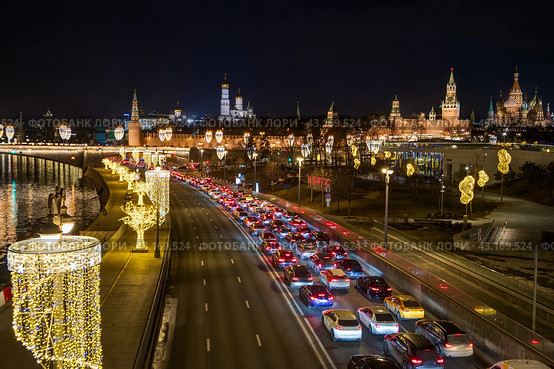 Москва, Россия. Вид сверху на Москворецкую набережную. На проезжей части автомобильная пробка. Множество автомобилей в дорожном заторе. Вдали Московский Кремль. Красивое уличное освещение и новогодние гирлянды на фонарях. Стоковое фото, фотограф Андрей Степанов / Фотобанк Лори