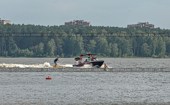 Моторная лодка мчится по воде с человеком на водных лыжах. город Железногорск, Красноярский край, Редакционное фото, фотограф Анатолий Володин / Фотобанк Лори