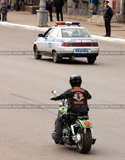 Мотоциклист едет за машиной милиции (2009 год). Редакционное фото, фотограф Михаил Митин / Фотобанк Лори