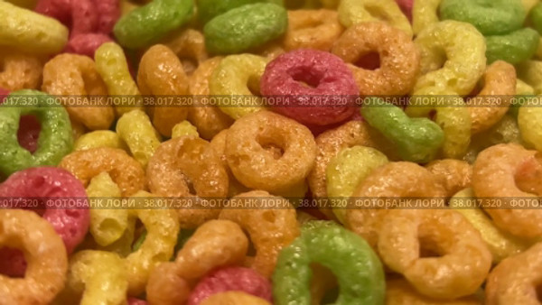 Multicolored breakfast cereals in the form of rings rotate in close-up. The concept of healthy food for breakfast. Стоковое видео, видеограф Ярославский Максим / Фотобанк Лори