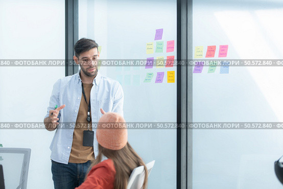Multiethnic startup business team on meeting in modern bright office interior brainstorming, working on laptop and tablet computer. Стоковое фото, агентство Ingram Publishing / Фотобанк Лори