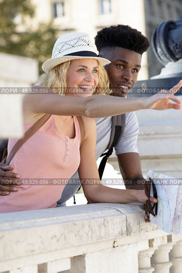 multiethnic traveller couple with local map pointing forwards. Стоковое фото, агентство Ingram Publishing / Фотобанк Лори