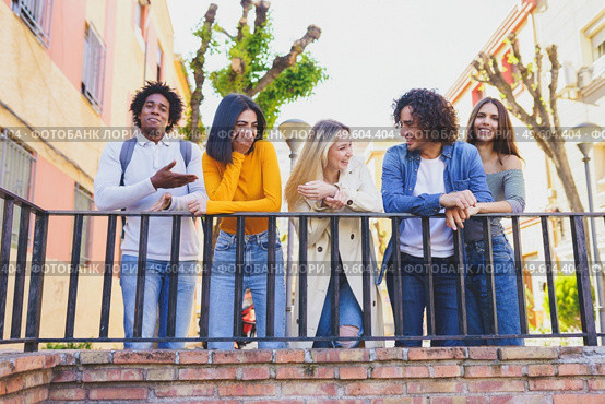 Multiracial group of young people talking together in the street. Students socializing.. Multiracial group of young people talking together in the street. Стоковое фото, агентство Ingram Publishing / Фотобанк Лори
