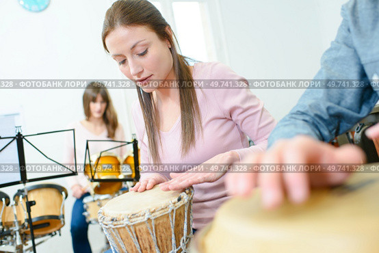 Music rehearsal, woman playing bongos. Стоковое фото, агентство Ingram Publishing / Фотобанк Лори