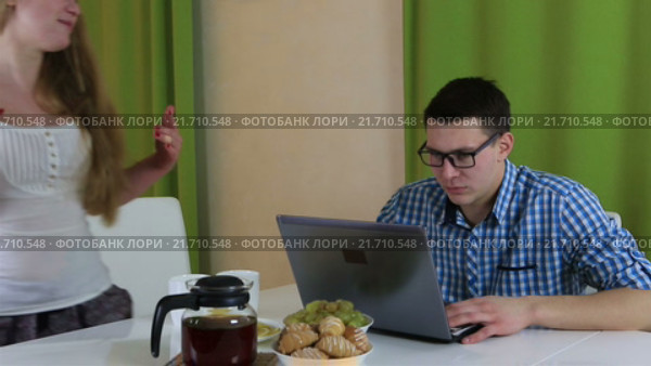 Муж не обращает внимания на жену, накрывающую на стол. Стоковое видео, видеограф Юлия Машкова / Фотобанк Лори