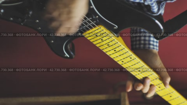 Мужчина демонстрирует свое мастерство игры на электрогитаре. Крупный план. Гитарист, играющий тяжелые рок-риффы, мастерски исполняет композицию. Краснодар, Россия, 20 ноября 2023 года. Редакционное видео, видеограф Воловодов Владимир / Фотобанк Лори