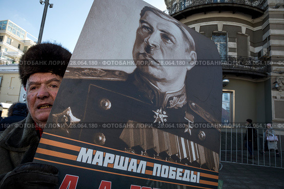 Мужчина держит портрет знаменитого военачальника, маршала Советского Союза Леонида Говорова во время демонстрации и митинга, посвященных столетию Советской Армии и Военно-Морского флота в городе Москве, Россия, 23 февраля 2018. Редакционное фото, фотограф Николай Винокуров / Фотобанк Лори