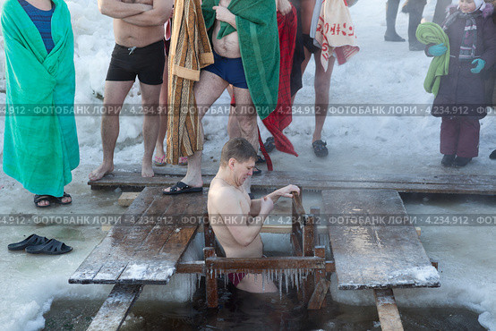 Мужчина креститься при окунании в прорубь (2013 год). Редакционное фото, фотограф Кекяляйнен Андрей / Фотобанк Лори