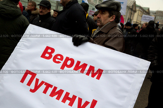 Мужчина с баннером "Верим Путину!" на шествии в поддержку соотечественников на Украине, Москва (2014 год). Редакционное фото, фотограф Николай Винокуров / Фотобанк Лори