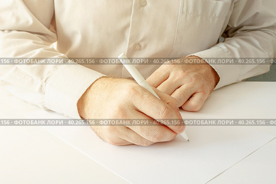 Мужчина, заполняющий пустой лист шариковой ручкой. A man fills a white blank paper form with a pen close-up. Стоковое фото, фотограф Валерий Елистратов / Фотобанк Лори