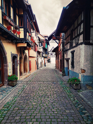 Narrow streets of the old Eguisheim village with half-timbered medieval houses along the famous wine route in Alsace, France. Стоковое фото, агентство Ingram Publishing / Фотобанк Лори
