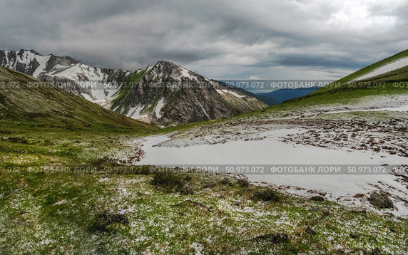 Natural rock formation on a green valley and snow riwer. Стоковое фото, фотограф Саблин Станислав / Фотобанк Лори
