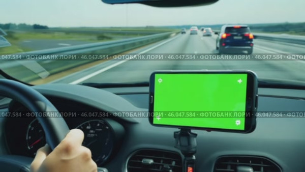 Navigator with green screen in the car dashboard. GPS module. Driver using smart phone with green background. Man steering wheel, driving on highway with smartphone navigation. Digital display monitor. Стоковое AI-видео, аниматор Марина Демидюк / Фотобанк Лори