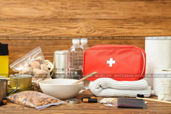Necessities for emergency bag on wooden table. Стоковое фото, фотограф Pixel_shot / Фотобанк Лори