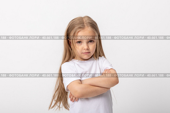 Negative human emotions, reactions and feelings. Isolated shot of moody displeased angry little girl crossing arms on her chest, pouting lips, having offended facial expression, being capricious. Стоковое фото, фотограф Ирина Михайличенко / Фотобанк Лори