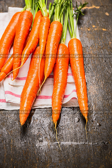 New carrots bunch on dark rustic wooden background, close up. Стоковое фото, агентство Ingram Publishing / Фотобанк Лори