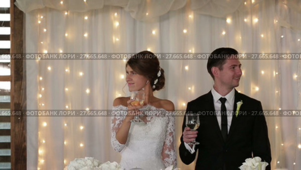 Newlyweds hold champagne in their hands. Стоковое видео, видеограф Roman Larchikov / Фотобанк Лори