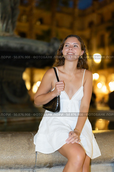 Night Royal square in Barcelona, girl in sundress is sitting on fountain fencing. Стоковое фото, фотограф Яков Филимонов / Фотобанк Лори