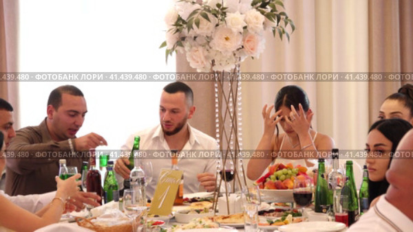 Nizhny Novgorod, Russia Kazan highway 29, 08.10.2023. Wedding. People are sitting at a round festive table with white tablecloths, eating delicious food and drinking wine. Нижний Новгород, Россия, Казанское шоссе, 29, 08.10.2023. Свадьба. Люди сидят за круглым праздничным столом, накрытым белыми скатертями, едят вкусную еду и пьют вино. Редакционное видео, видеограф Egor Sarantstv / Фотобанк Лори