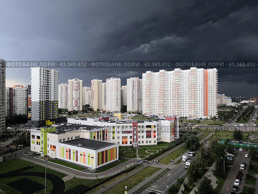 Новая школа в районе новостроек в Химках под грозовым небом (2020 год). Стоковое фото, фотограф Александр Замараев / Фотобанк Лори