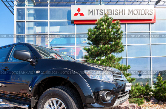 Новый автомобиль Mitsubishi Pajero Sport стоит возле автосалона официального дилера (2016 год). Редакционное фото, фотограф FotograFF / Фотобанк Лори