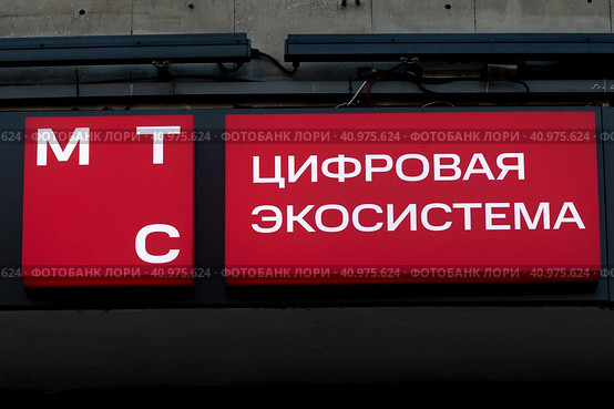 Новый логотип телекоммуникационной компании МТС после смены дизайна на офисе компании в центре города Москвы, Россия (2023 год). Редакционное фото, фотограф Николай Винокуров / Фотобанк Лори