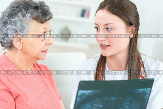 Nurse showing xray to senior citizen. Стоковое фото, агентство Ingram Publishing / Фотобанк Лори