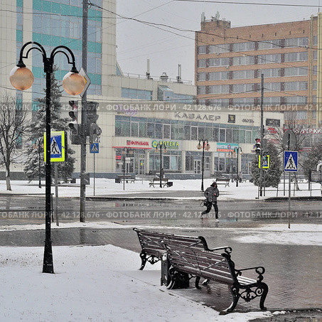 Одинокий пешеход в промозглую, с мокрым снегом погоду перебегает через городской перекресток (2022 год). Редакционное фото, фотограф Владимир Литвинов / Фотобанк Лори