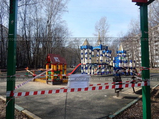 Огороженная полосатой лентой детская площадка во дворе жилых домов на Сахалинской улице в дни самоизоляции при коронавирусе Covid-19. Район Гольяново. Город Москва. Россия (2020 год). Редакционное фото, фотограф lana1501 / Фотобанк Лори
