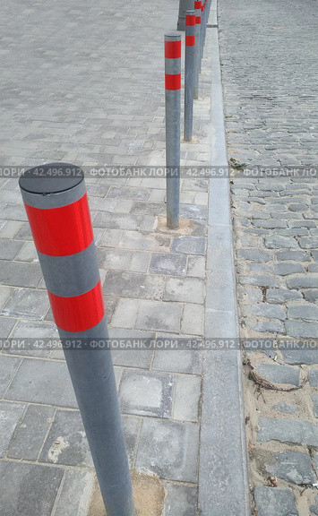 Ограничительные столбики на проезжей части дороги. Restrictive posts between the pedestrian sidewalk and the road. Стоковое фото, фотограф Татьяна Д / Фотобанк Лори