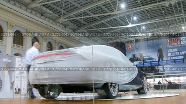Охранник одевает чехол на новый автомобиль на Неделе моды (таймлапс) (2012 год). Редакционное видео, видеограф Losevsky Pavel / Фотобанк Лори
