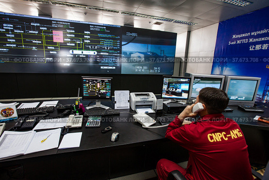 Oil refinery plant. Operation control center and operator in red work wear controlling process. CNPC company. (2012 год). Редакционное фото, фотограф Alexey Rezvykh / Фотобанк Лори